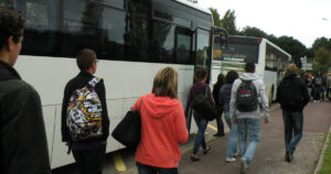 Photo de bus avec des lycées se dirigeant vers l'avant pour monter à bord